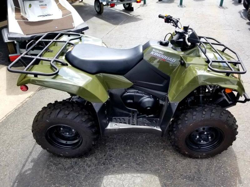 Dark green 2020 Suzuki KingQuad® ATV parked on a lot surrounded by other vehicles.